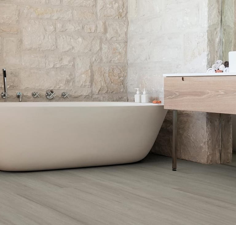 A bath with stone walls and wood floors