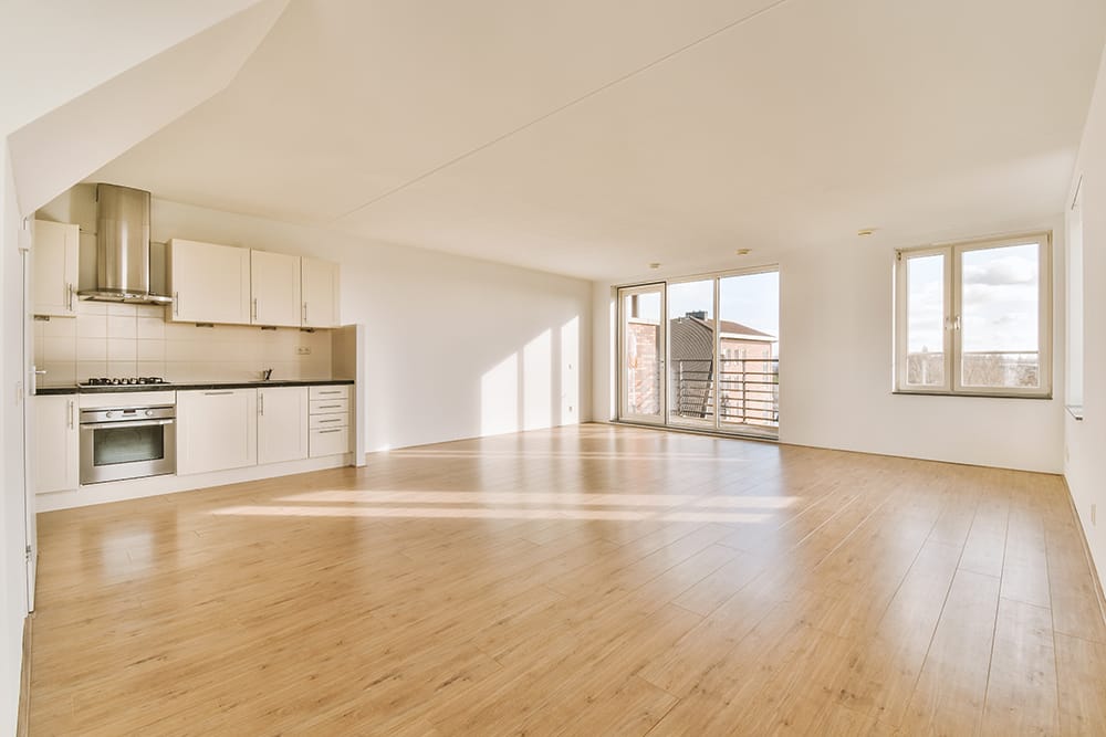 Spacious empty room with corner kitchen